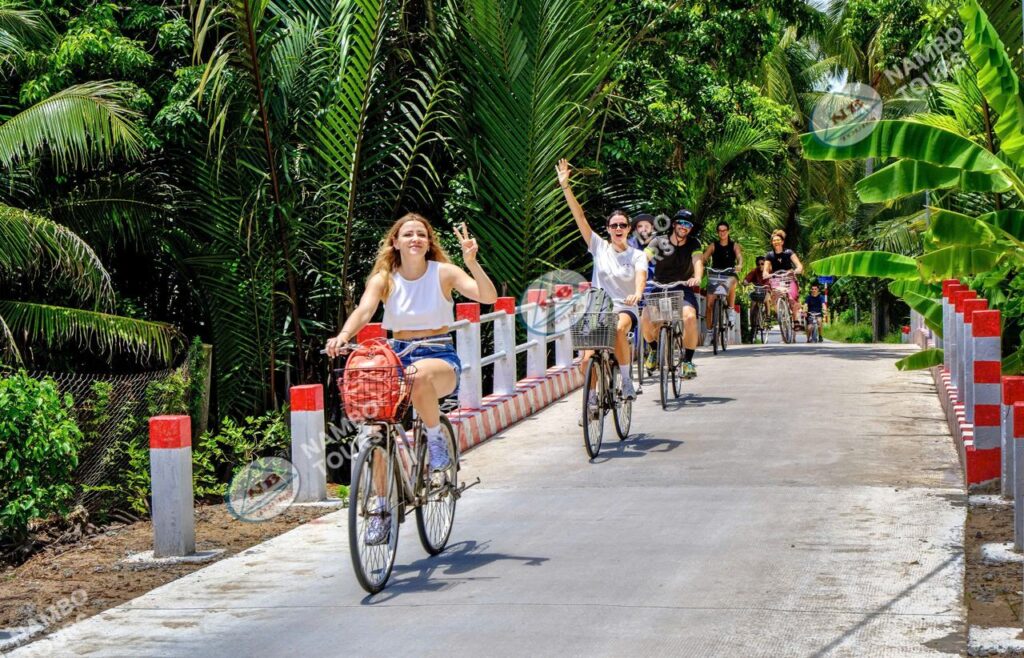 Travellers cycling along a coconut lane on a Ben Tre cycling tour
