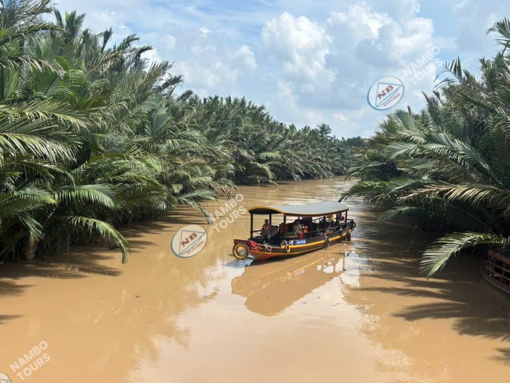 Covered sampan on a quiet water-coconut canal in Ben Tre