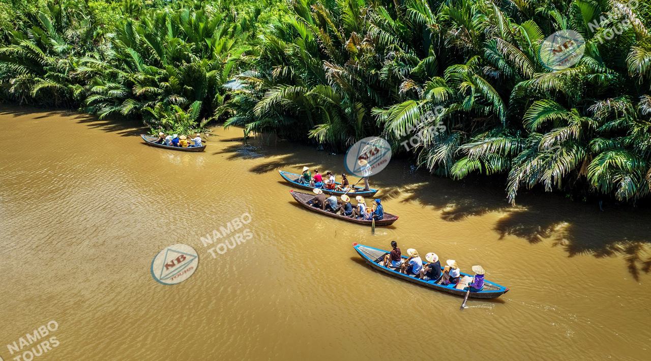 Sampans gliding through a water-coconut canal – one of the best things to do in Ben Tre